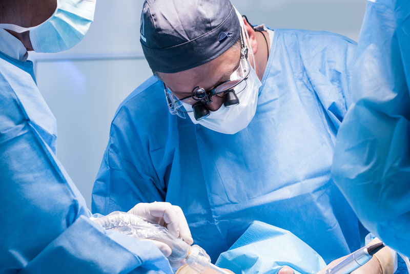 oral surgeon performing peri-implantitis procedure