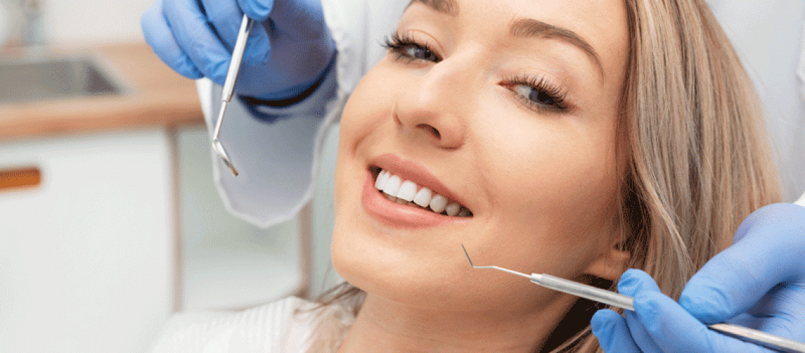 women in dental office awaiting her procedure, dental tools in doctors hand
