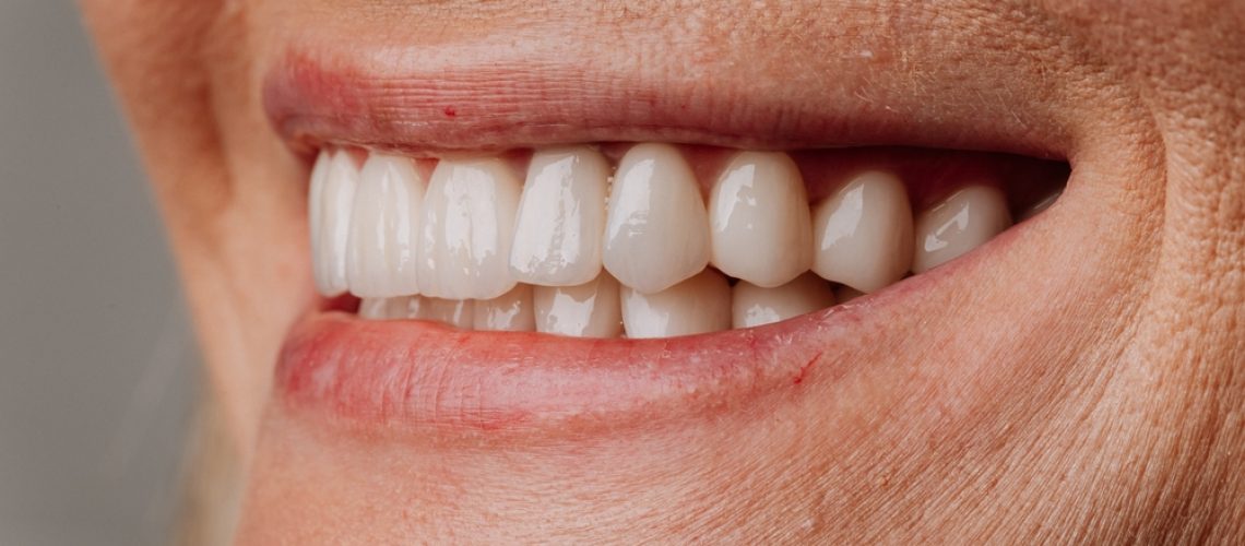 A collaborative approach to implants is displayed, showing an oral surgeon placing the implant post while a general dentist crafts the final crown, emphasizing teamwork for safer care and better results. No text on image.