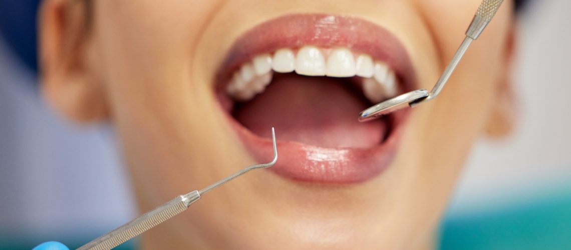 A dentist is showing a patient a 3D model of their jaw with a dental implant in place, demonstrating the safety and precision of the procedure. No text on image.